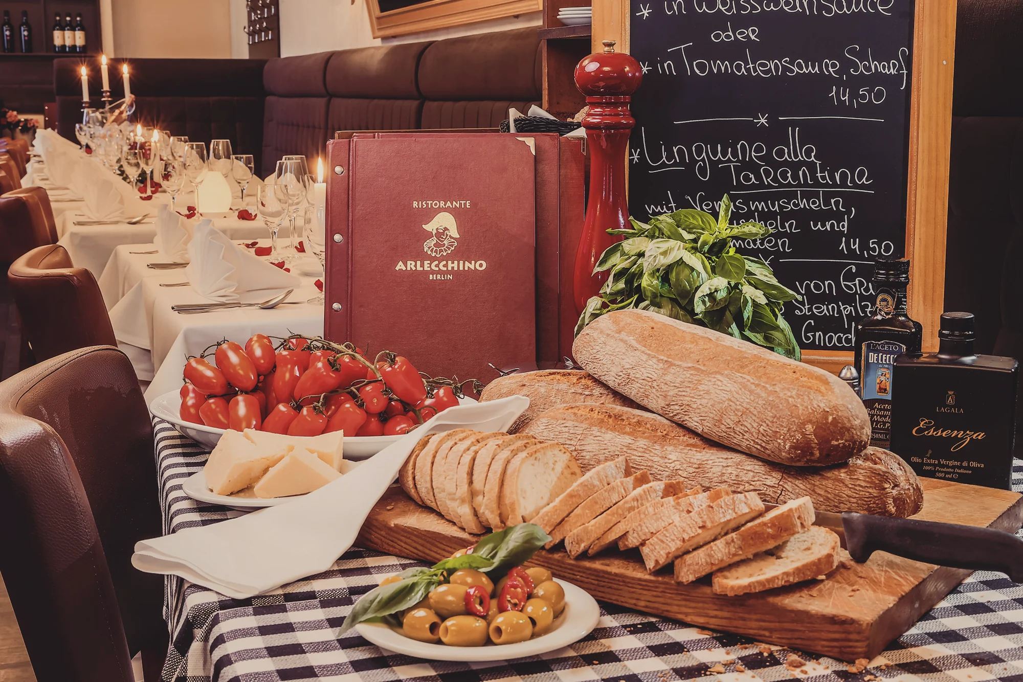 Frisches Brot, Oliven und Erdbeeren neben der Speisekarte des Ristorante Arlecchino